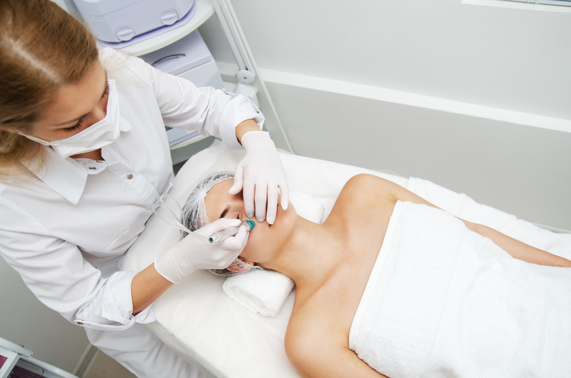 Woman getting ultrasound face beauty treatment in medical spa center